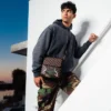 MESSENGER-SLING-TASCHE „SHARKS IN PARIS“ MIT GOLDENER REISSVERSCHLUSSTASCHE AUF DER AUSSENSEITE
